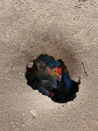 Дыра в асфальте стала урной для мусора в Никеле Дыра в асфальте стала урной для мусора в Никеле