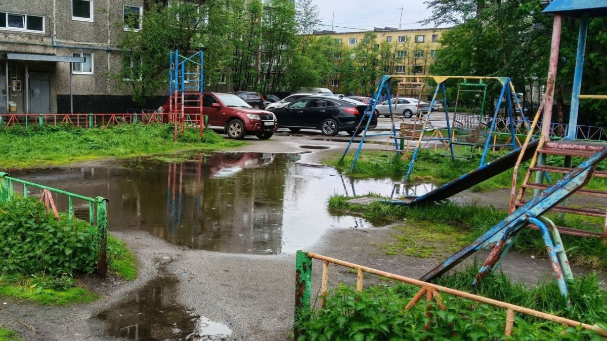 Большая лужа посредине территории детской площадки