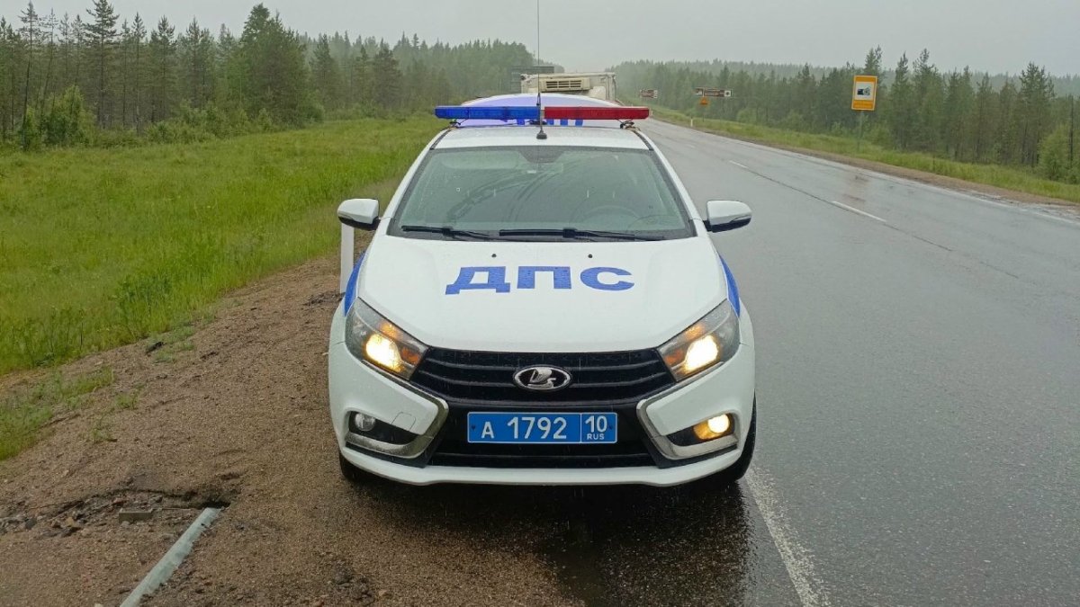 Машина ГИБДД стоит на обочине на трассе в сильный дождь