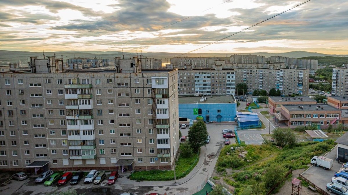 Дома девятиэтажные во дворе и припаркованные машины летом