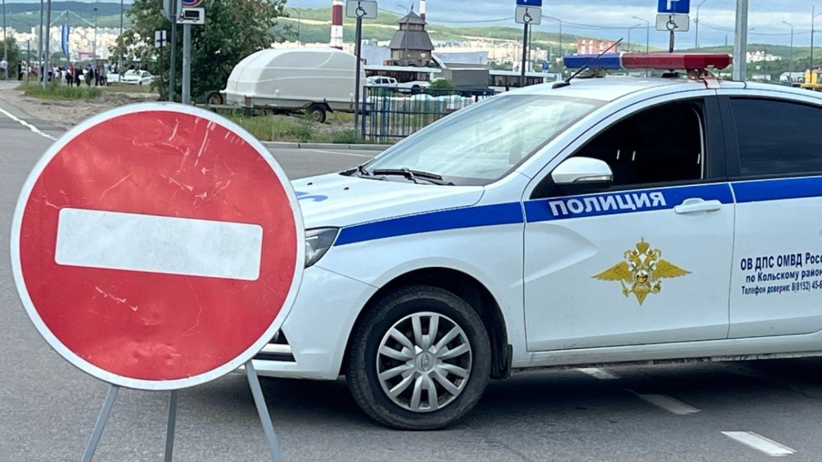 Служебная машина ГАИ стоит на дороге рядом со знаком проезд запрещен