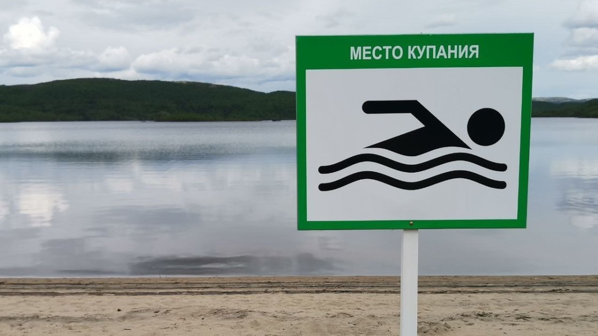 Табличка с указанием места для купания на пляже возле озера