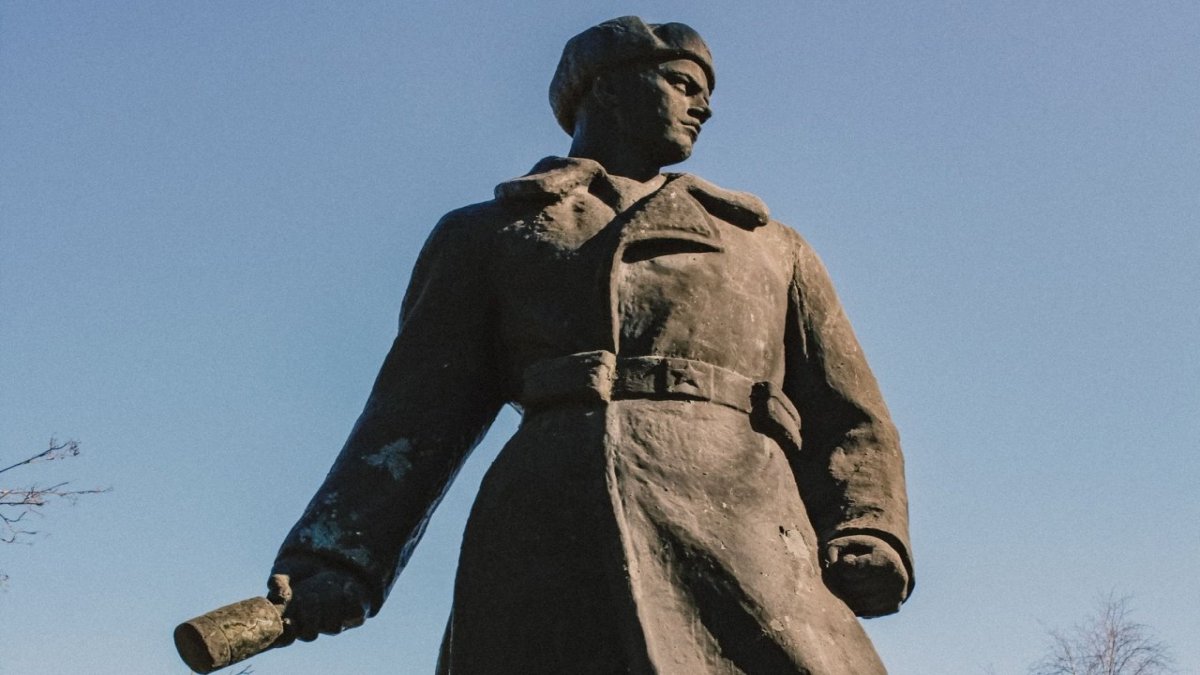 Памятник бойца в шинели на фоне голубого неба