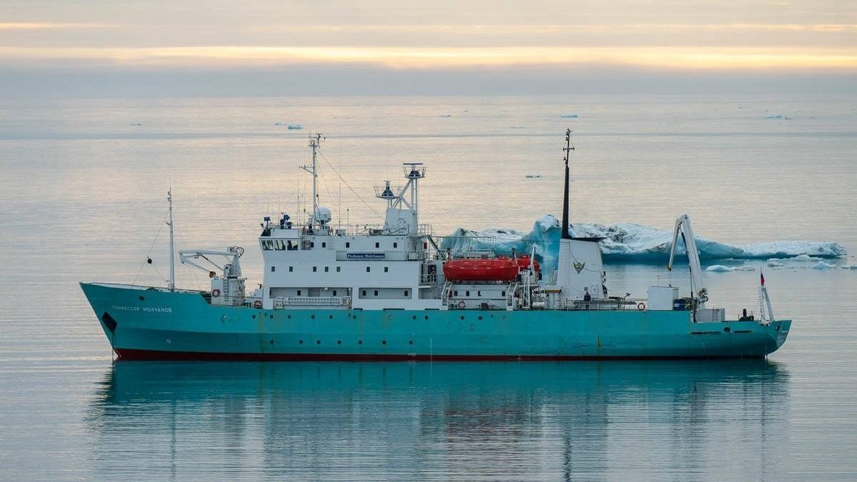 Судно стоит на рейде в море на фоне заката