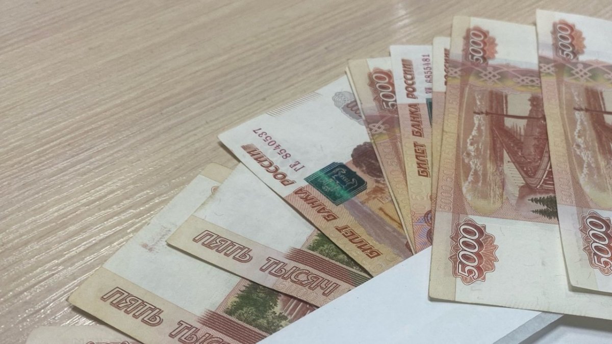Пятитысячные купюры лежат на белом конверте  столе