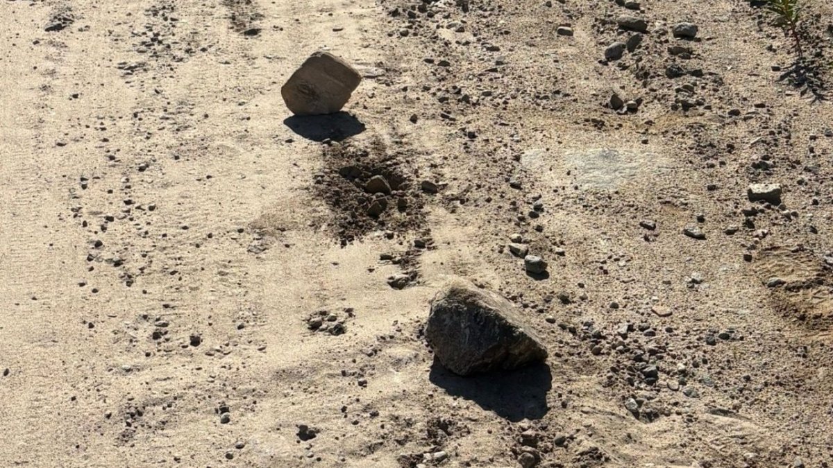 Большие камни лежат на проселочной дороге летом