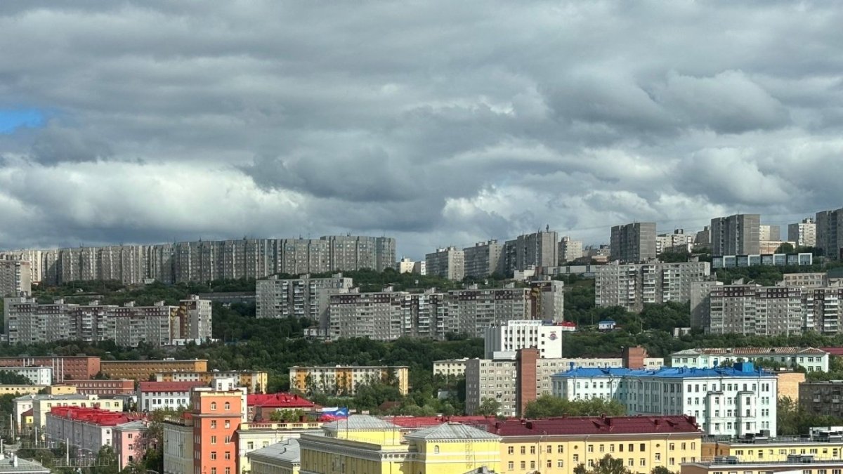 Многоэтажные дома на фоне облачного неба летом
