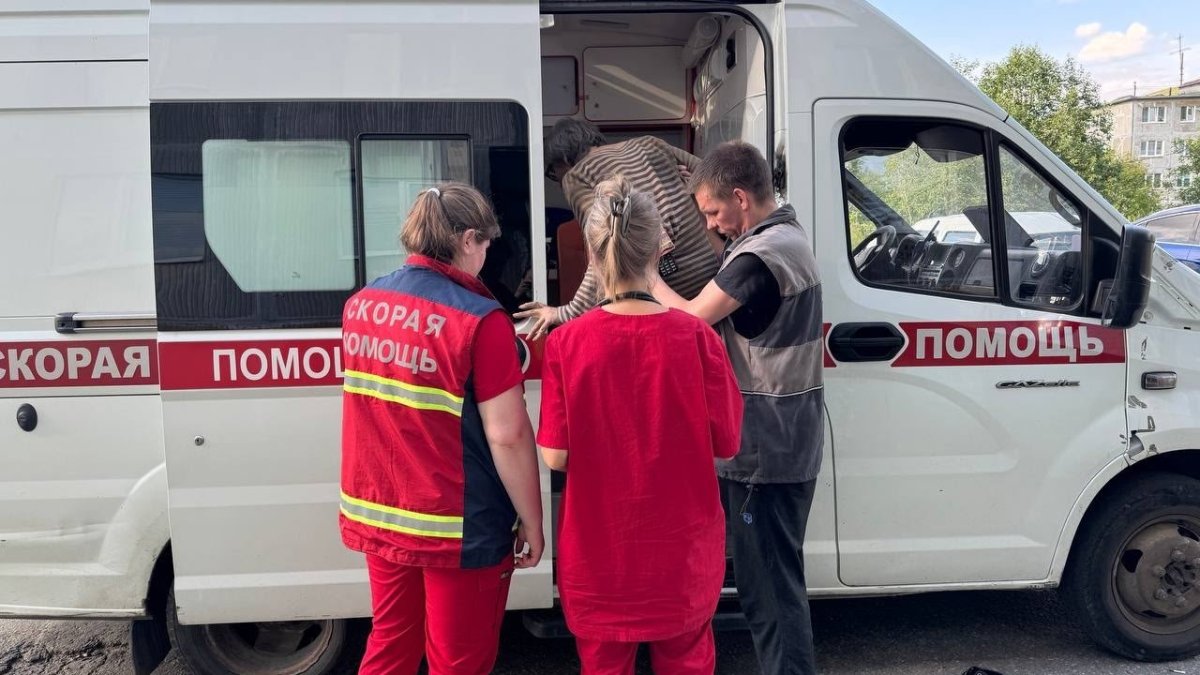 Мужчину сотрудники скорой помощи заводят в машину