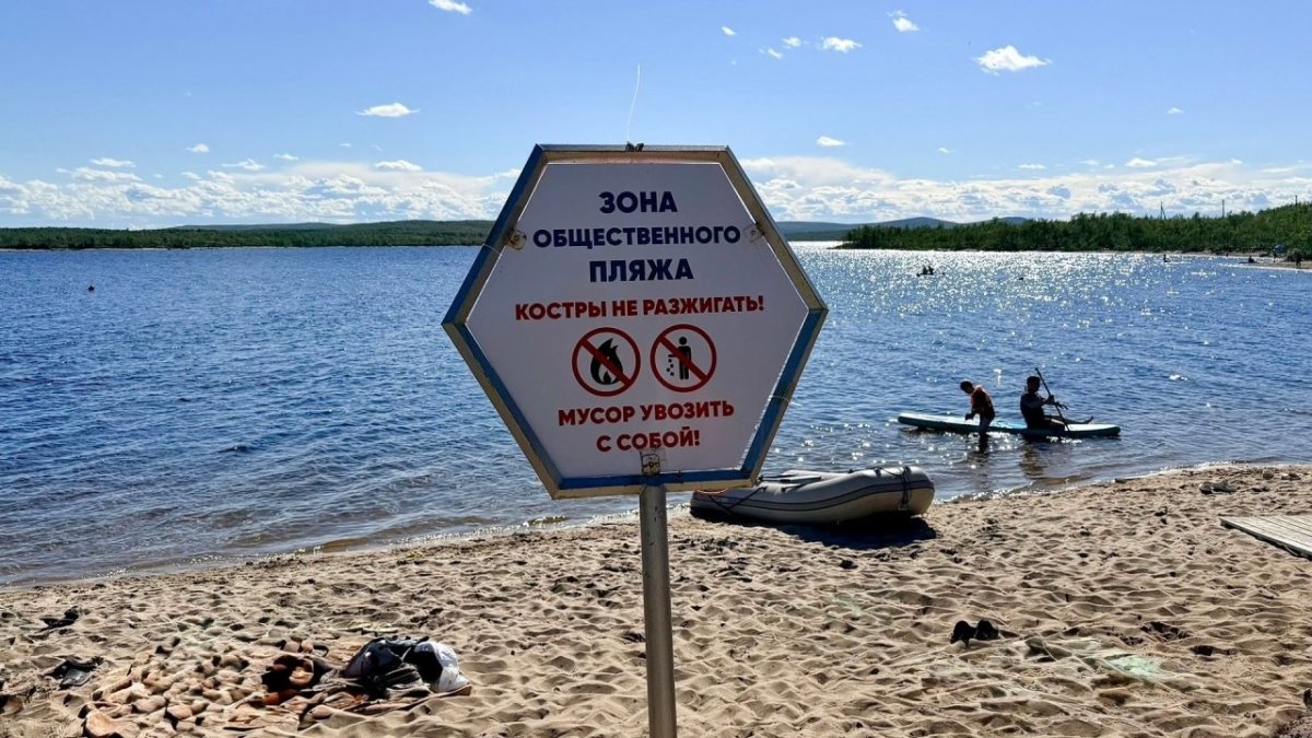 Табличка с напоминанием о вывозе за собой мусора на пляже возле озера