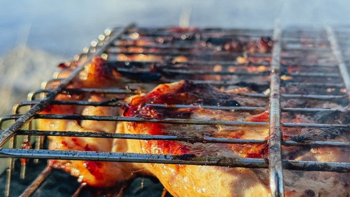 Румяная корочка на мясе под решеткой на мангале