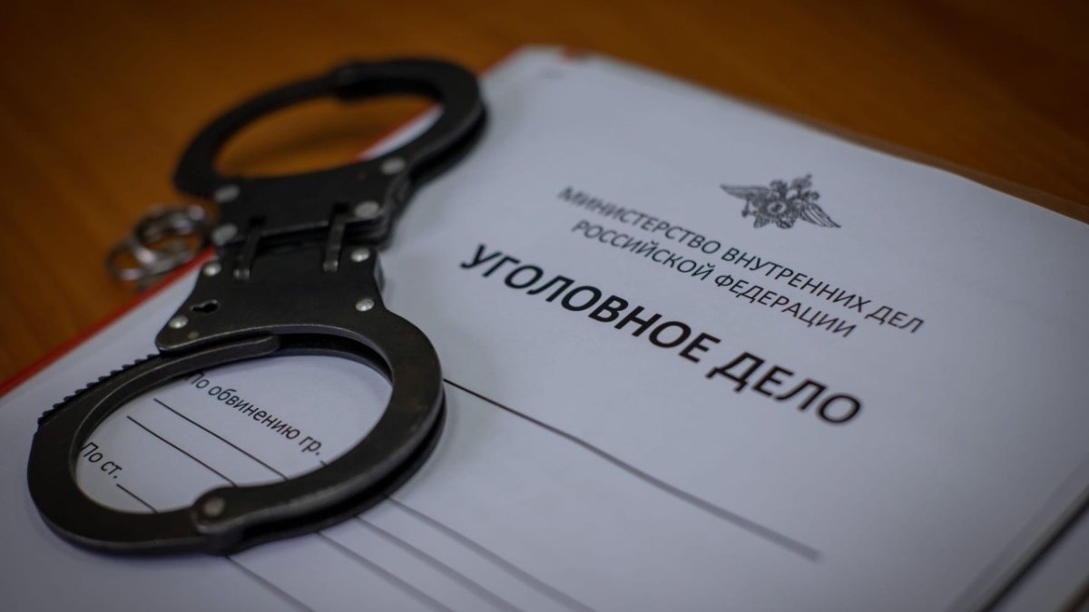 Наручники лежат на уголовном деле