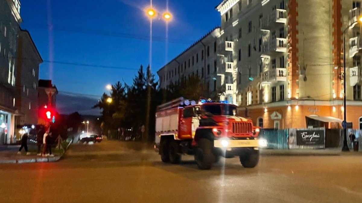 Пожарная машина едет по освещзенному городу вечером летом