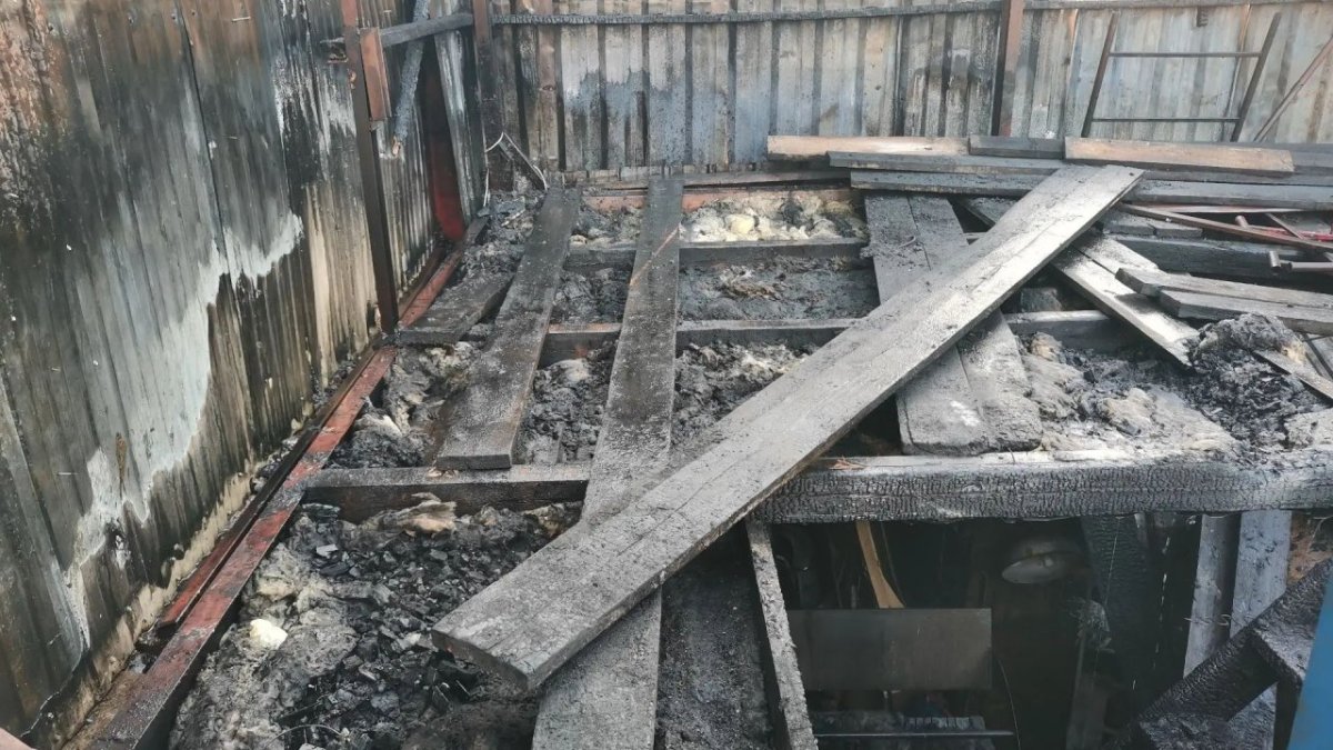 Обгоревшие доски в гараже после пожара