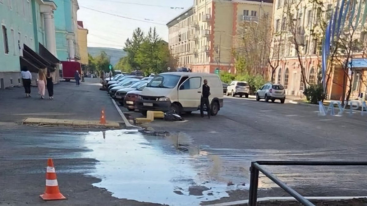 Разлитый гудрон посоеди асфальта в городе летом.