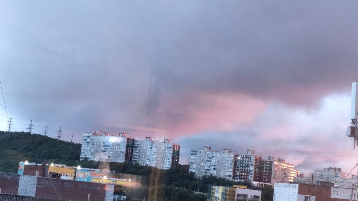 Розового цвета облака в летнем вечернем небе.