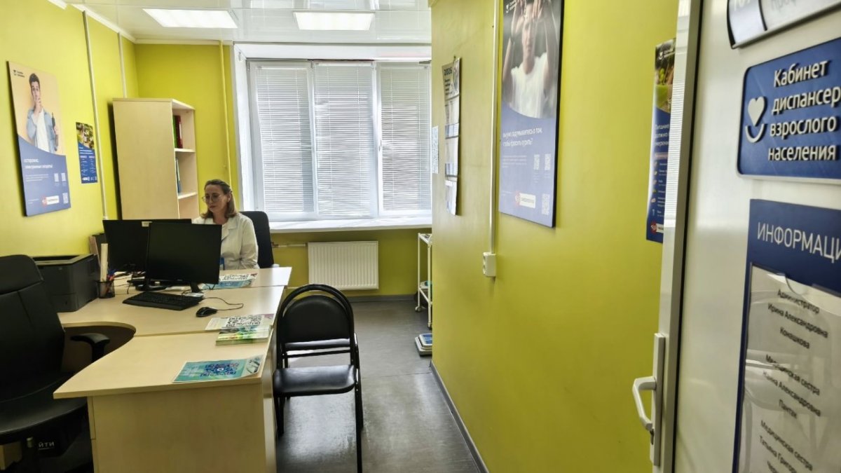 Врач сидит за столом в медицинском кабинете.