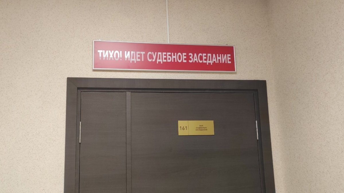 Табличка с надписью о том, что иден заседание суда.