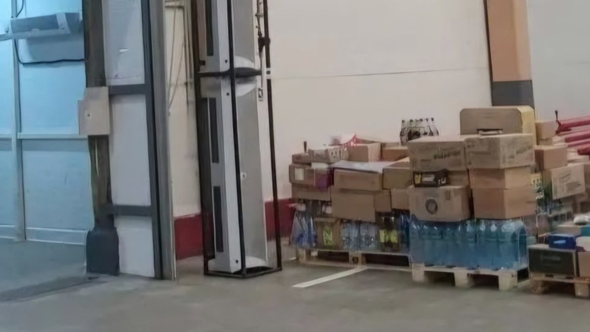 На складе стоят коробки с продукцией и бутылки с водой.