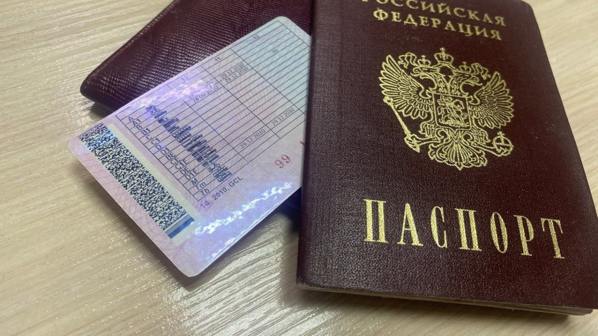 Водительские права и паспорт лежат на столе.