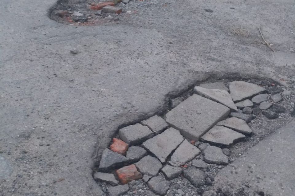 «Глубокие и с острыми краями»: мурманчанам с ул. Баумана приходится самим заделывать ямы во дворе